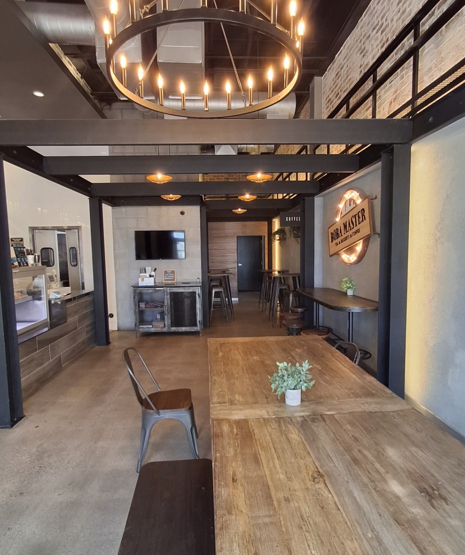 Long communal wooden table beneath a circular chandelier